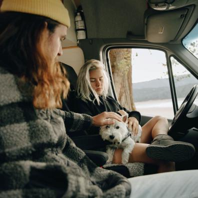 Man and Woman Sitting Inside the Campervan with Their Dog